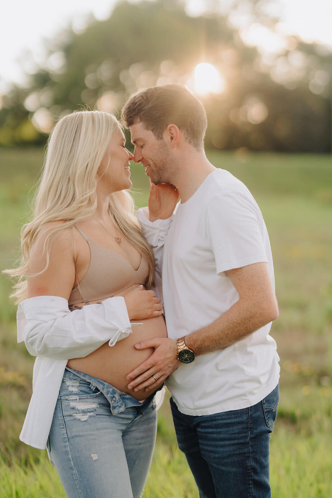 Couple standing in field at  maternity session in Finger Lakes, New York