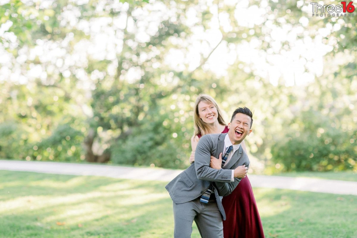 Bride to be tickles her Groom as they both laugh hysterically