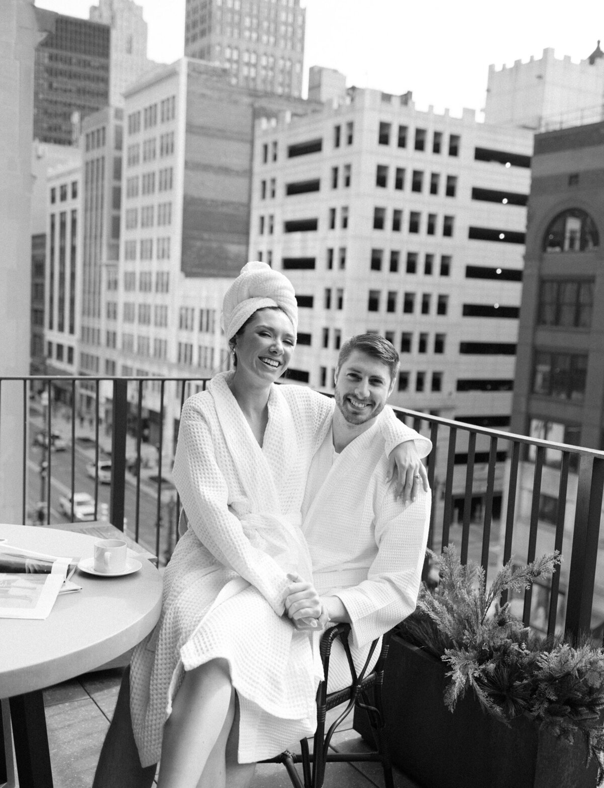 a couple in bathrobes laugh together on the balcony of a posh Detroit hotel, Shinola