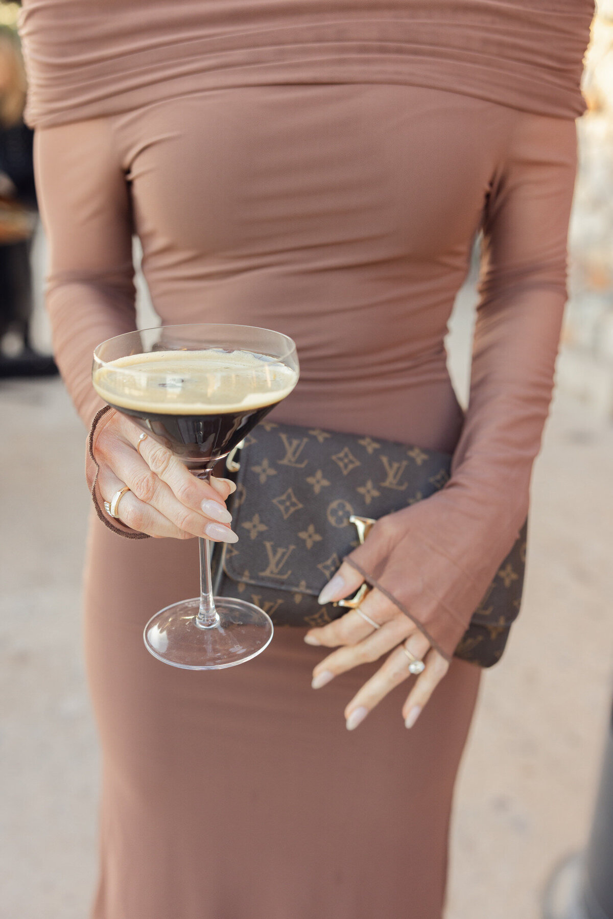 Mocha mousse wedding guest attire holding espresso martini