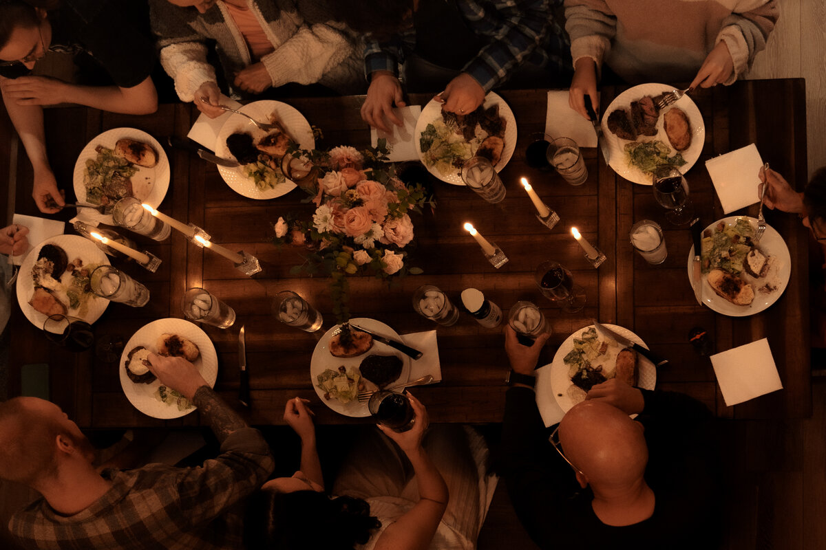 Aerial view of a family sharing a toast at a candlelit dinner after a couple married in an intimate reception in Oregon