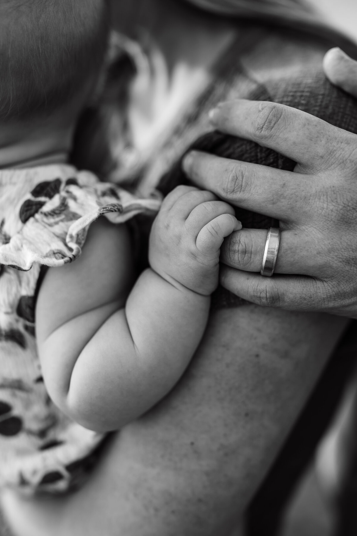 Closeup of dad holding a baby's fingers.
