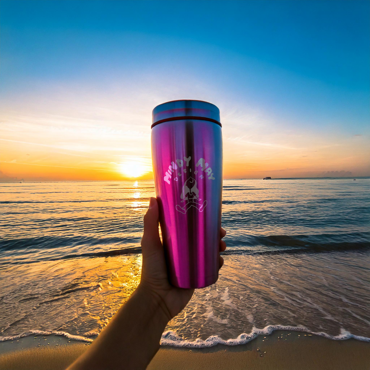 engraved-pink-metal-tumbler-held-up-at-the-beach