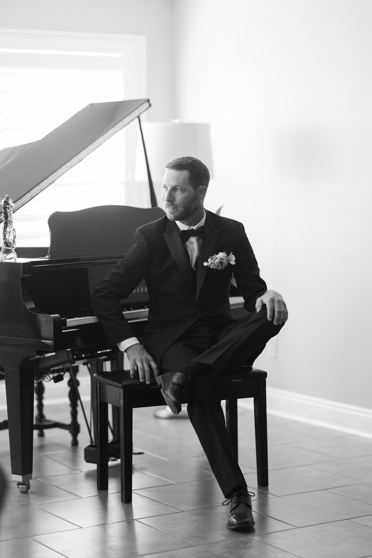 Groom sitting next to a piano