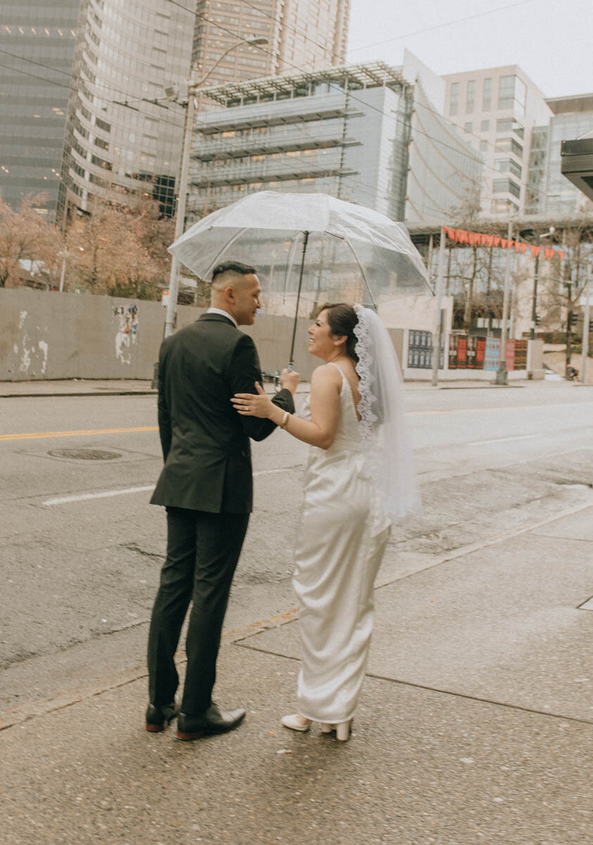 couple looking at each other while groom holds umbrella for the bride
