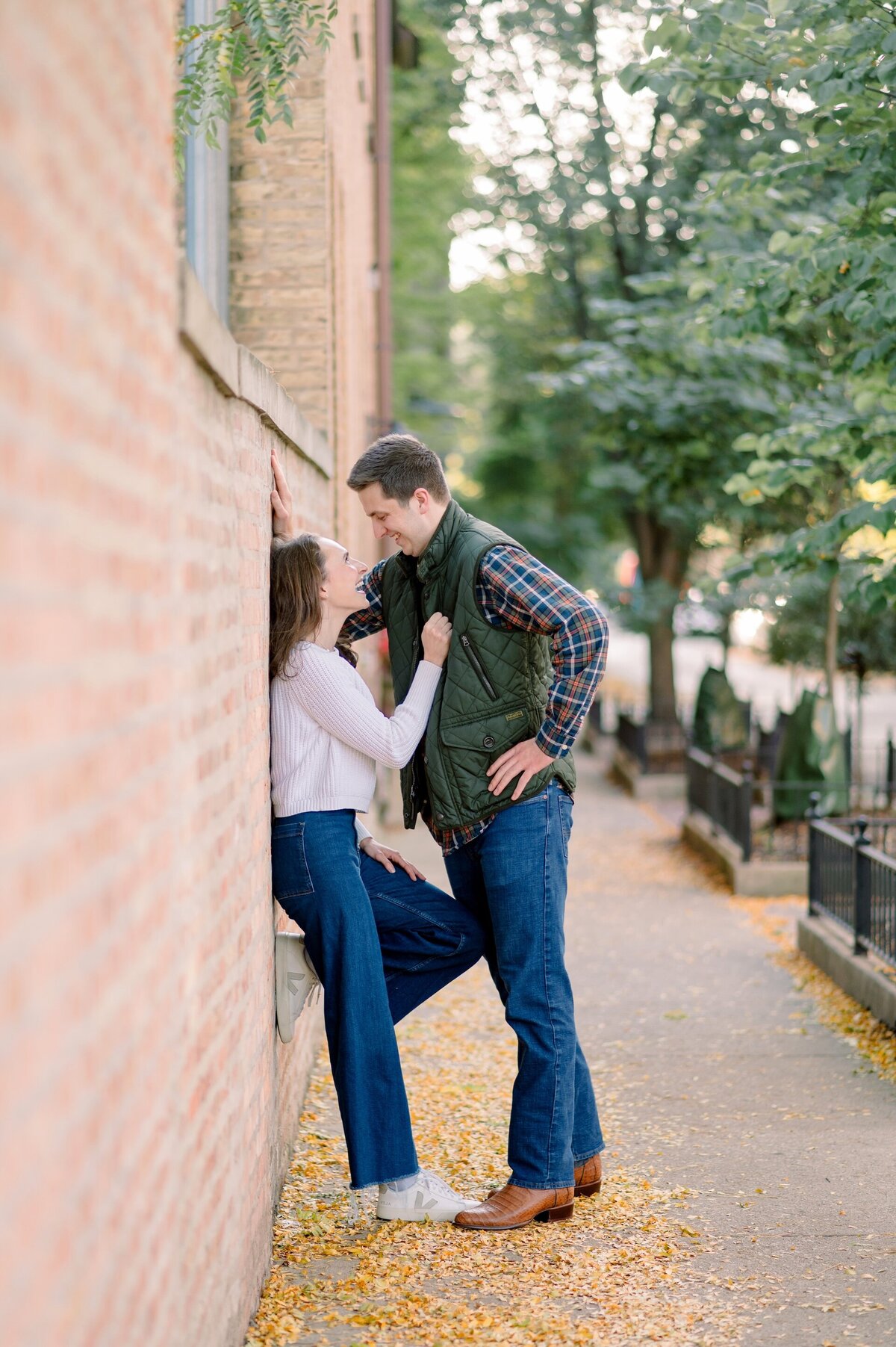 man about to kiss fiance up against a brick wall