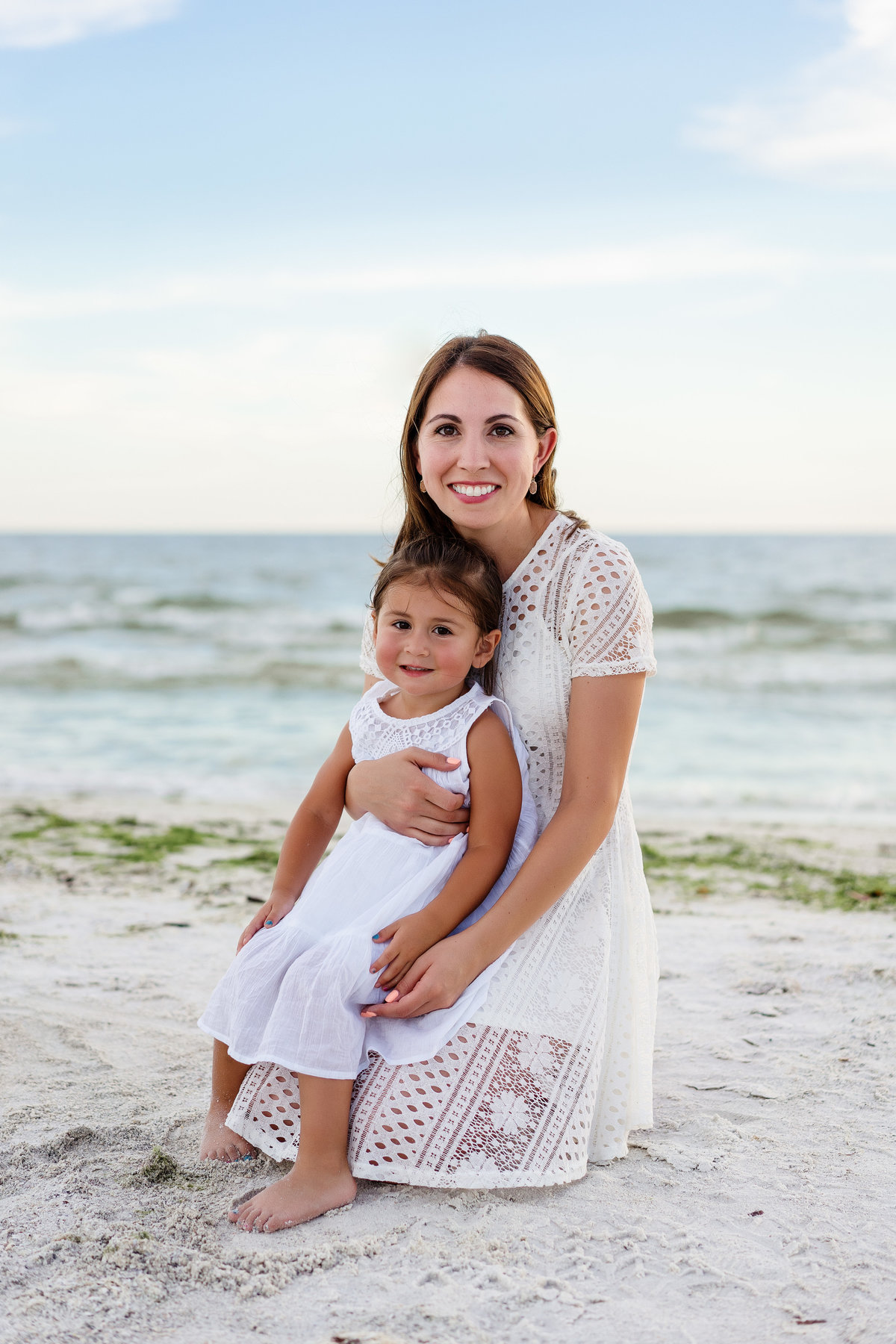 Mom with young daughter on her lap for a family photo on Fort Myers Beach Florida