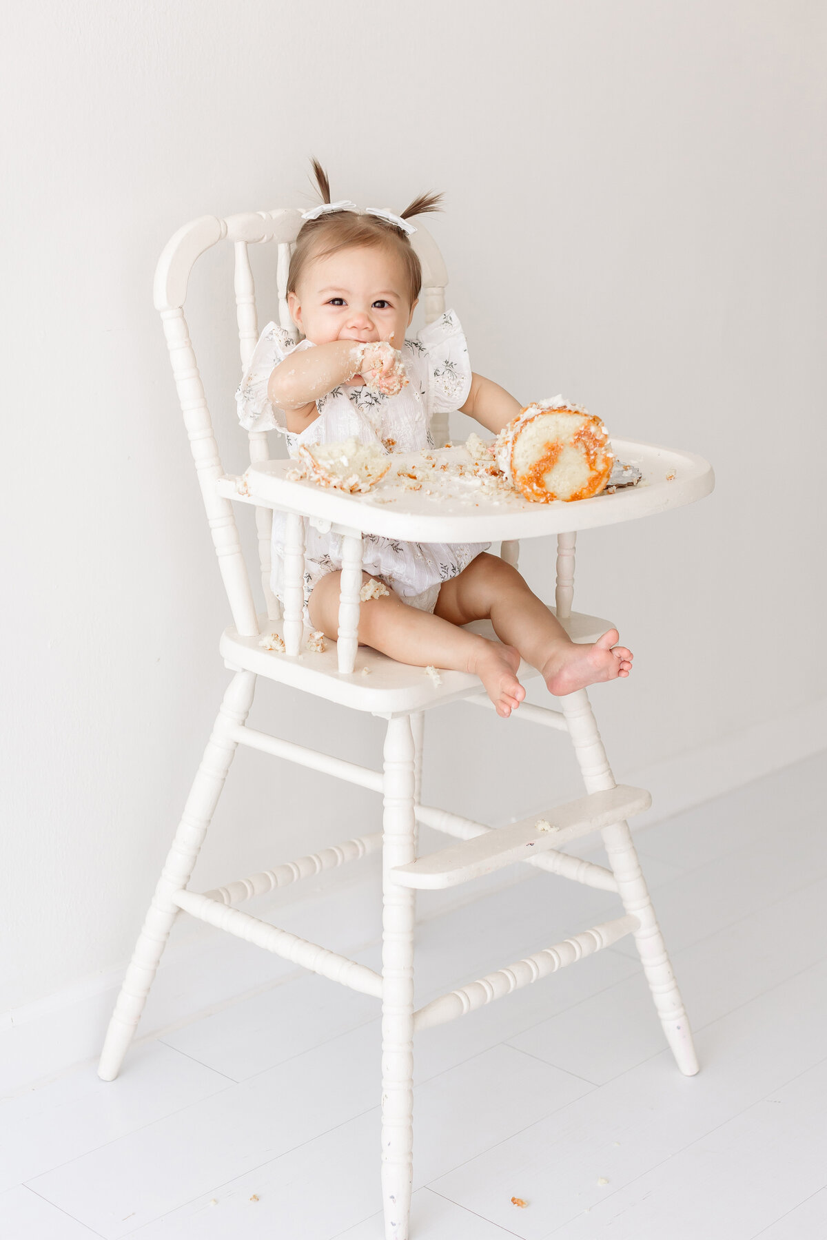 baby eating cake on high chair