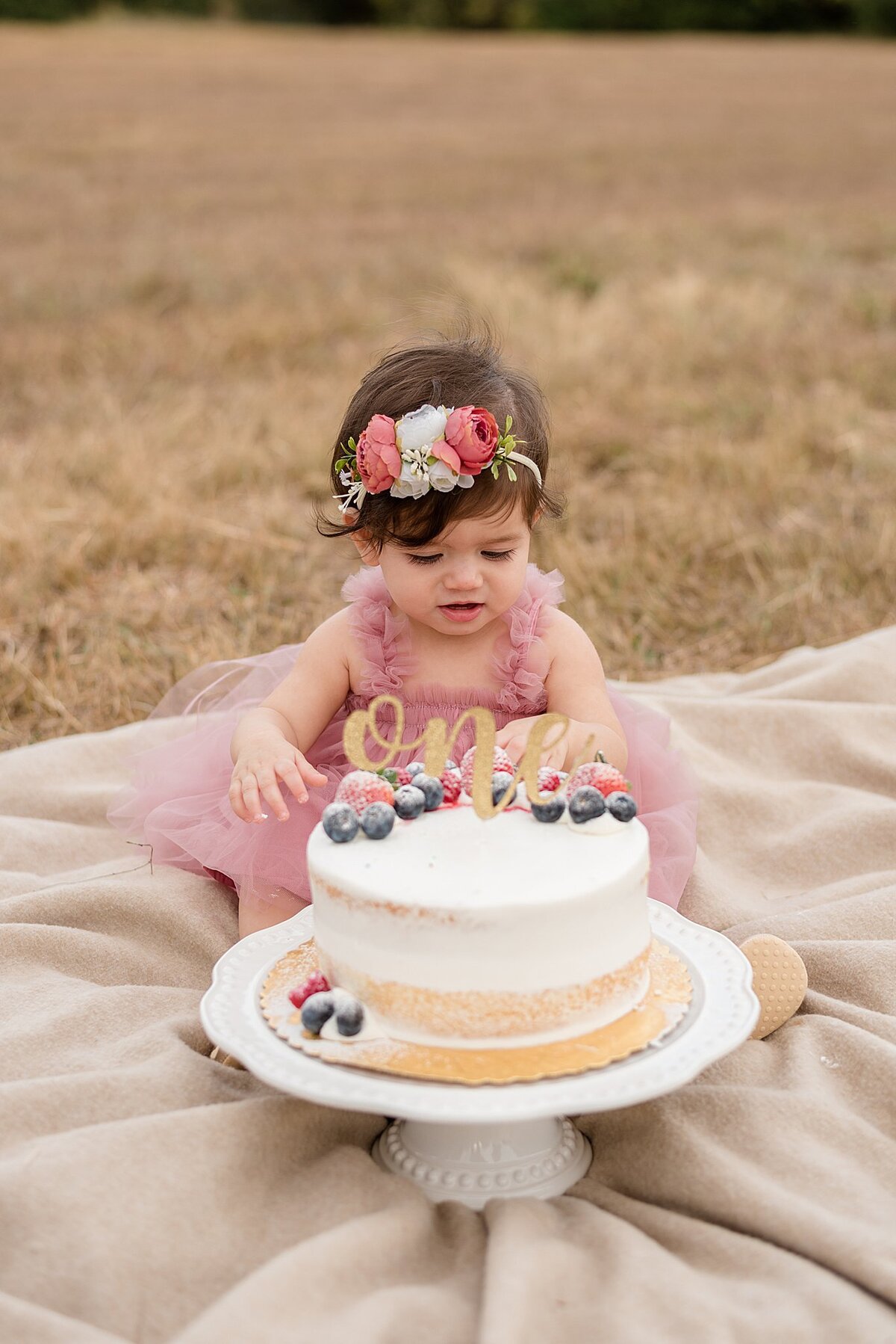 little girl touching cake