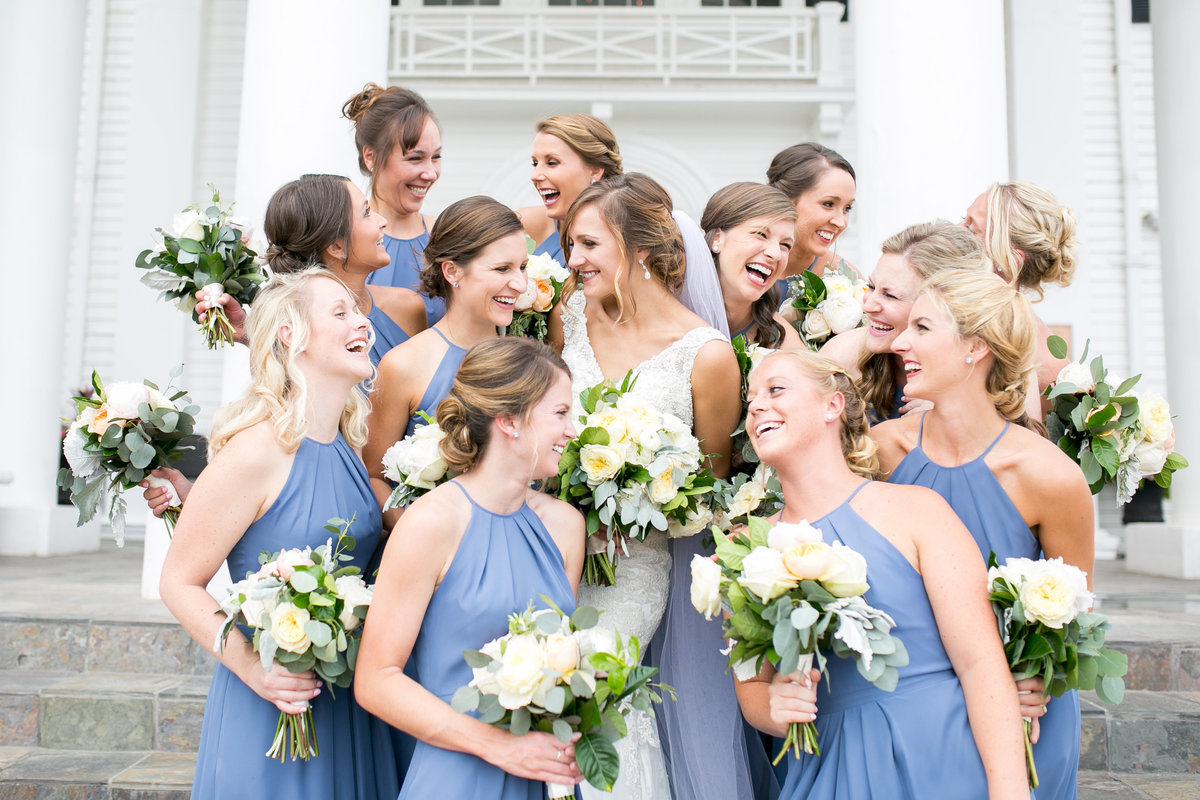 Bride with all her bridesmaids laughing together
