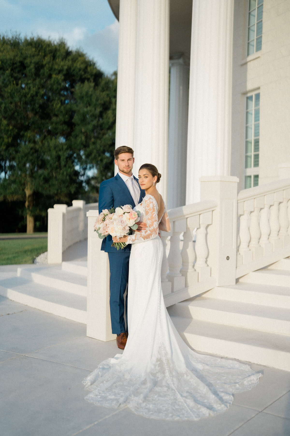 Bride and groom standing outside in a romantic setting, capturing a timeless wedding moment with elegant floral details by In Full Bloom Event Planning & Design