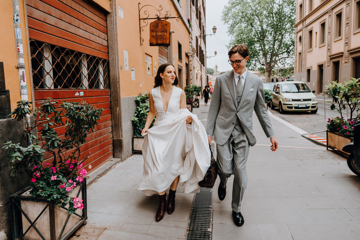 Couple walking across a Roman street holding hands.