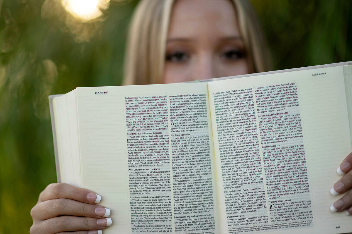 Details of a bible being held up by a blonde high school senior
