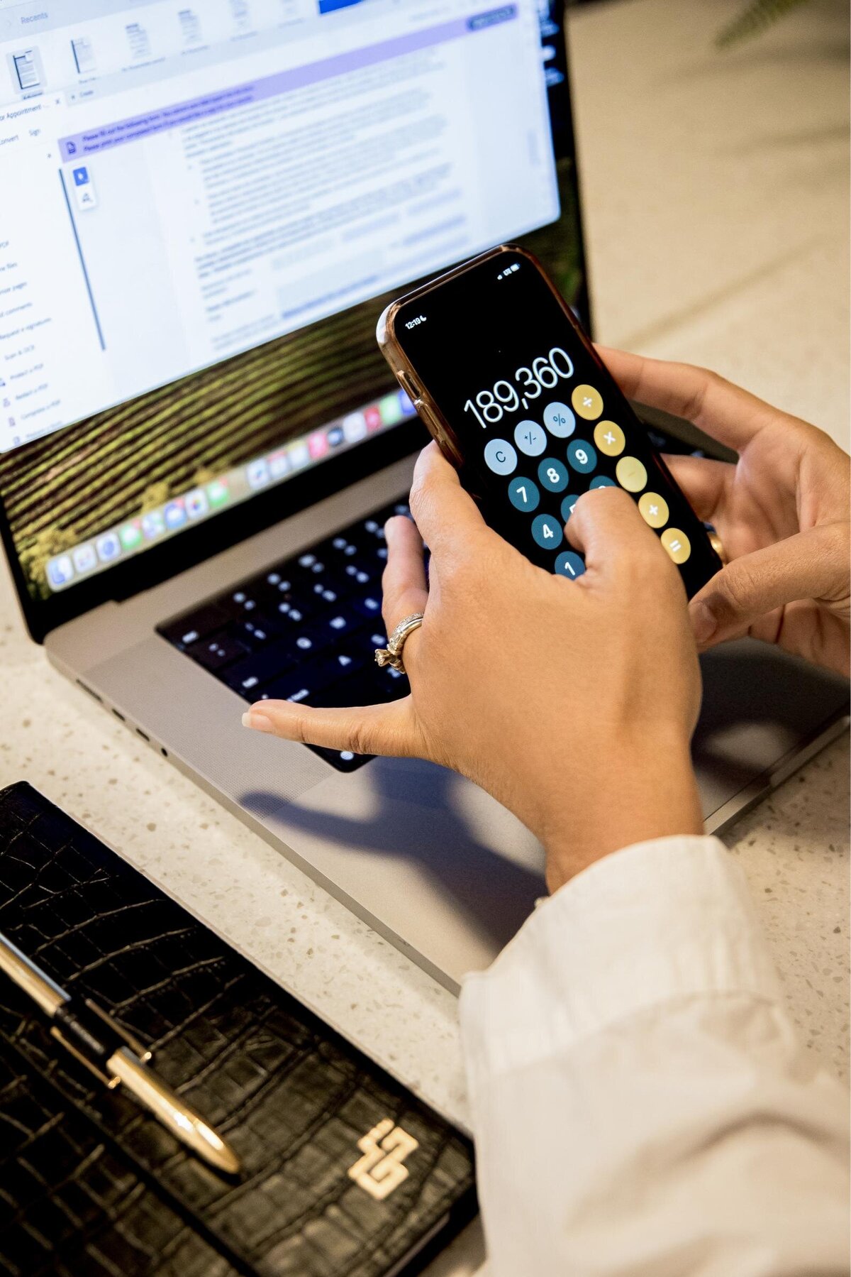 Carolina holding her phone while calculating, showcasing focus and professionalism. Ideal for branding photoshoot ideas related to tech-savvy work.