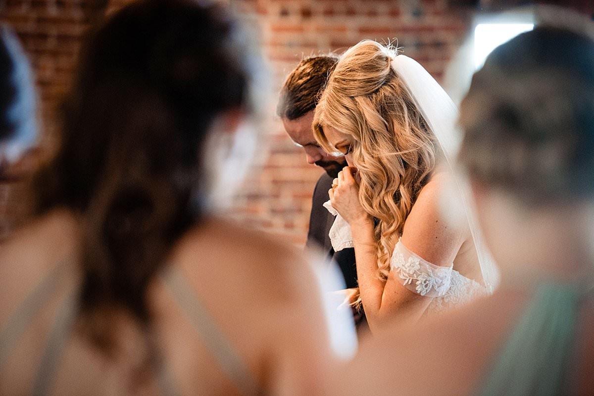 Bride wiping away tears of joy during her emotional ceremony