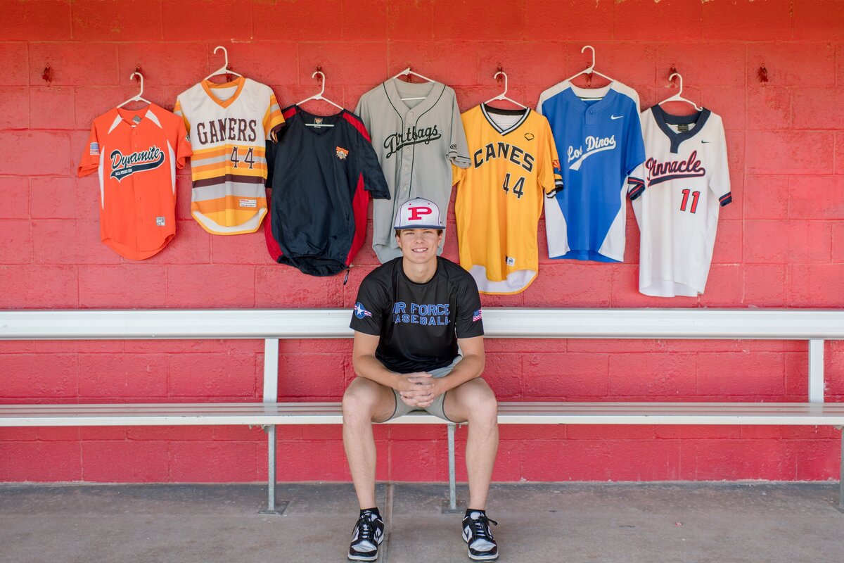 senior boy with his all of his high baseball jesery's from his youth