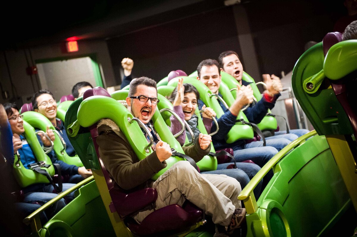 Attendees cheer as they prepare to ride a roller coaster at Universal Studios in LA as part of an offsite event