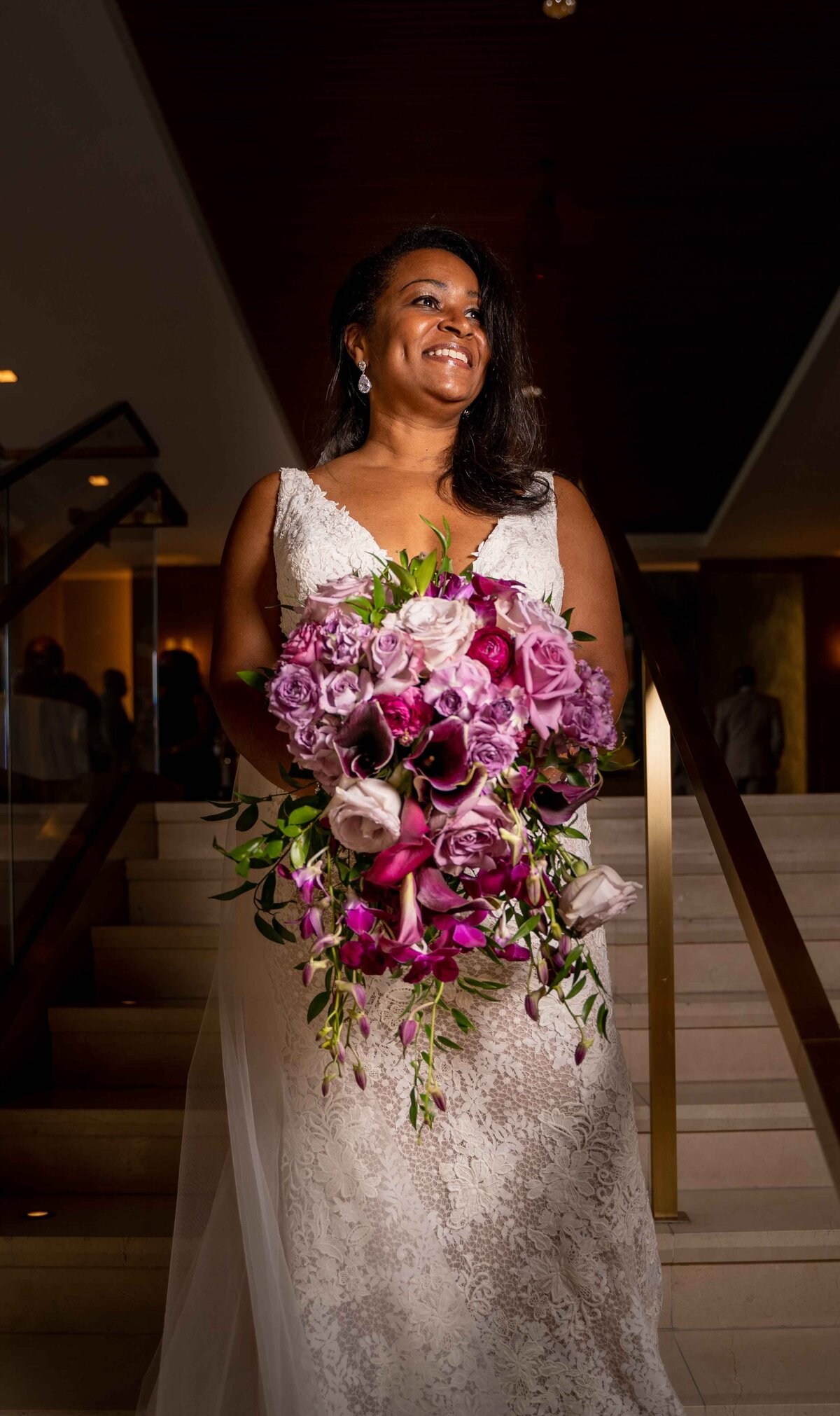 Bride stands on steps with bouquet at the intercontinental hotel in Washington DC