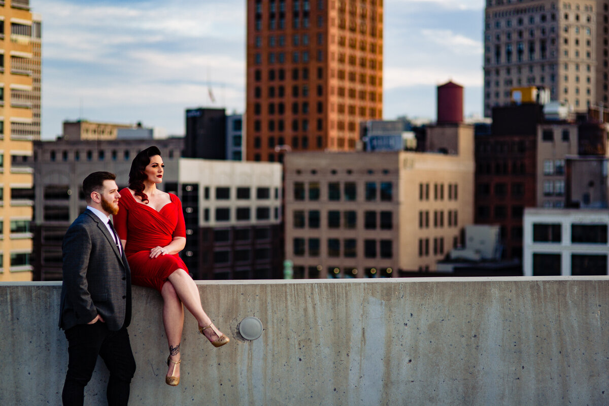 Engagement photos the the Z Park Garage in Detroit Michigan. The bride wore a red dress and the groom wore a gray suit. The detroit skyline is in the background.  Photo By Adore Wedding Photography. Toledo Wedding Photographers