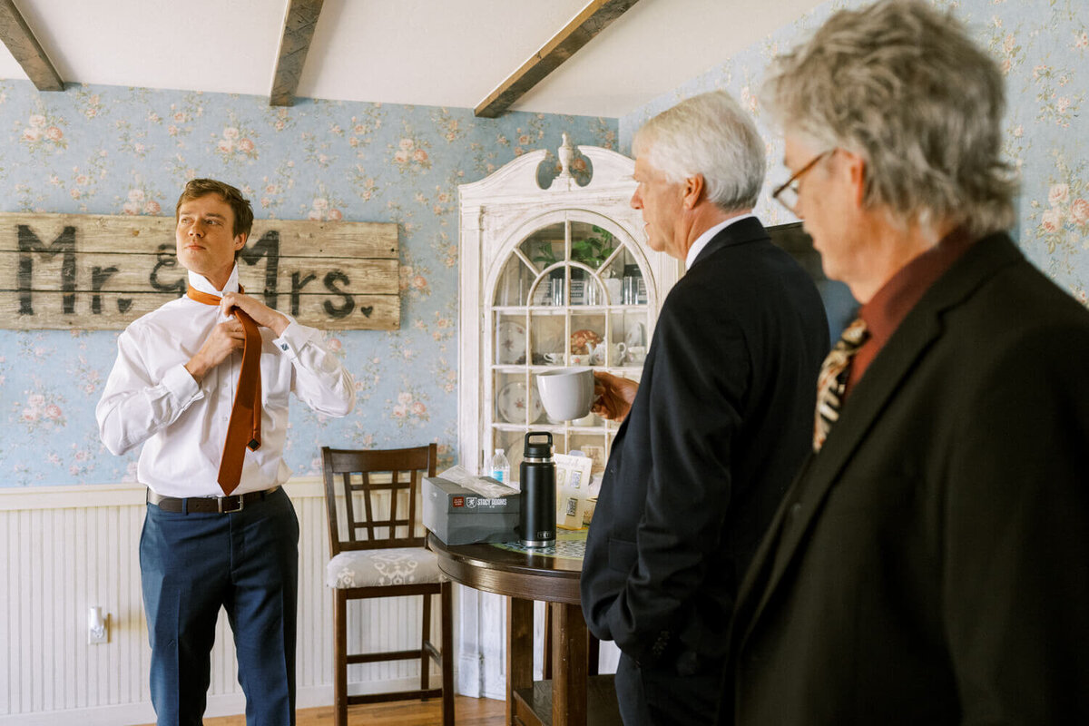 men-watching-man-fix-his-tie