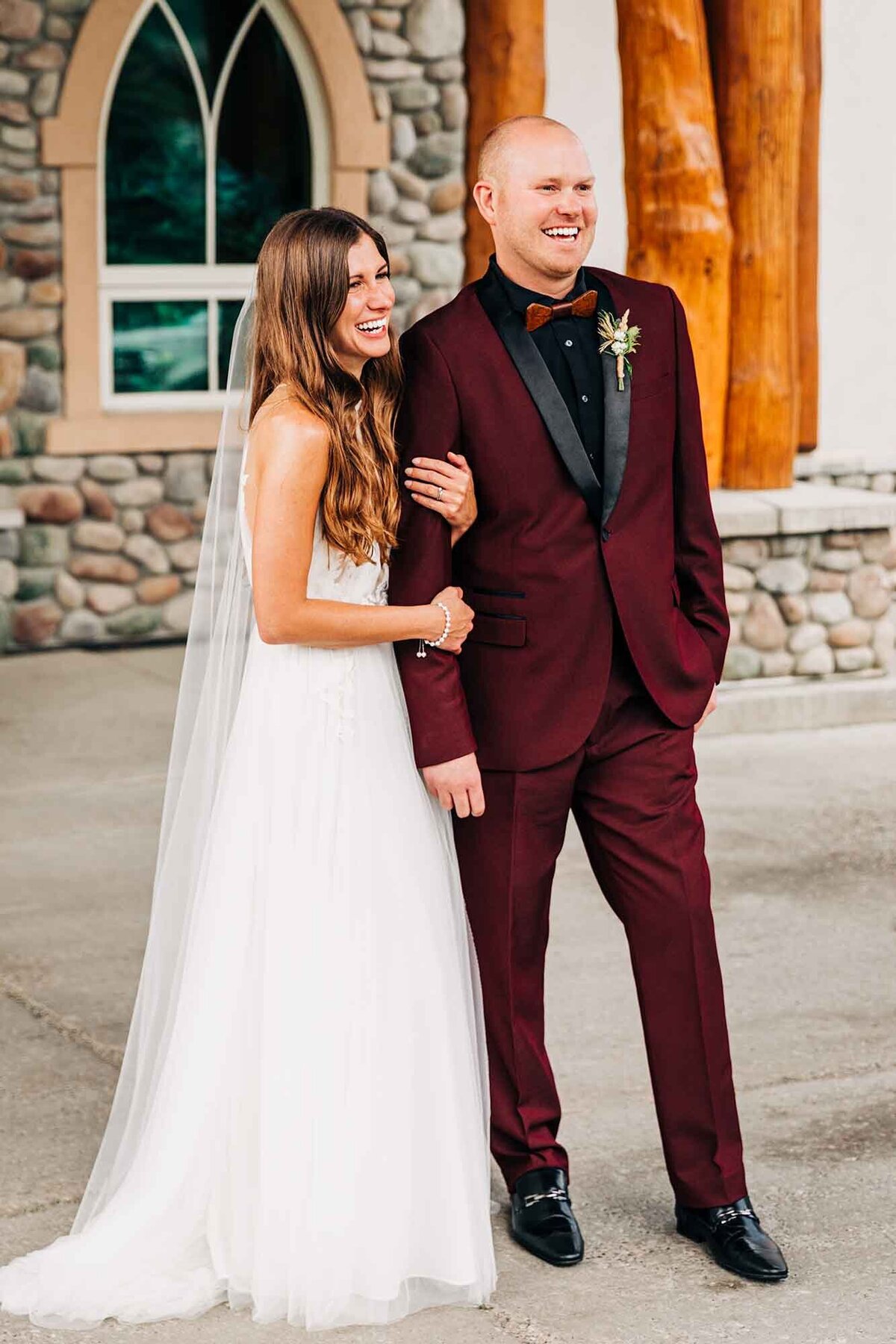 Portrait of bride and groom standing in front of Big Sky Chapel, Big Sky, MT