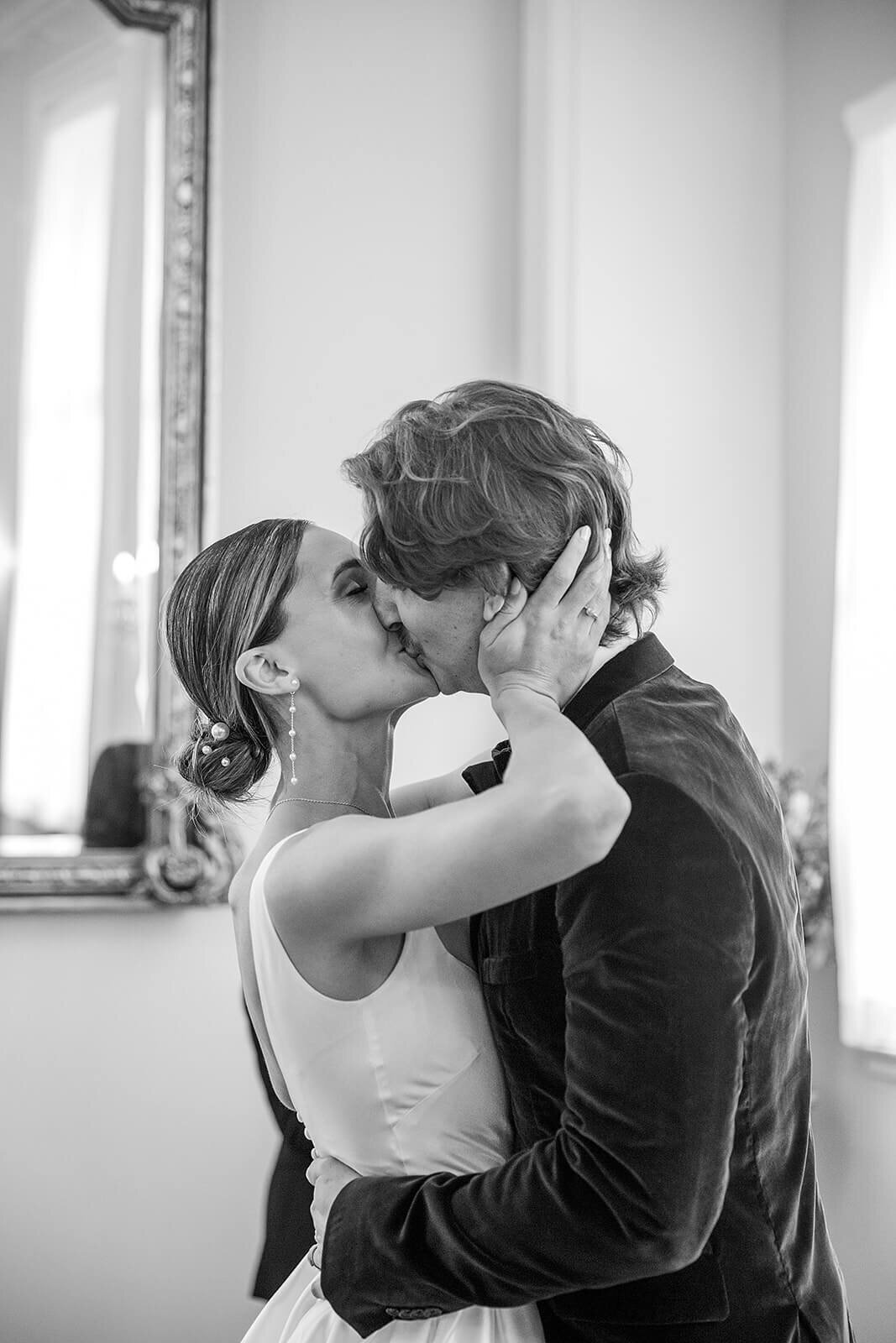 Groom and bride kiss in Brydon Room, Chelsea Town Hall