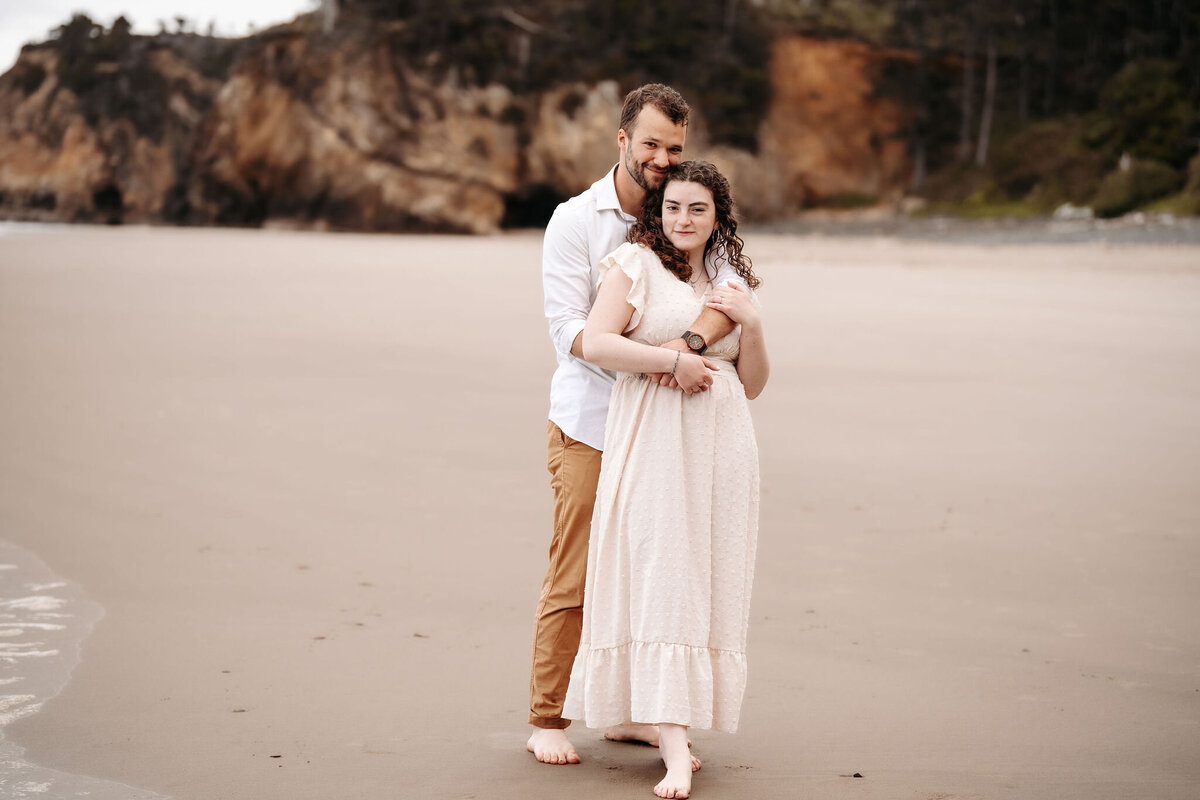 engaged couple hugging on the beach
