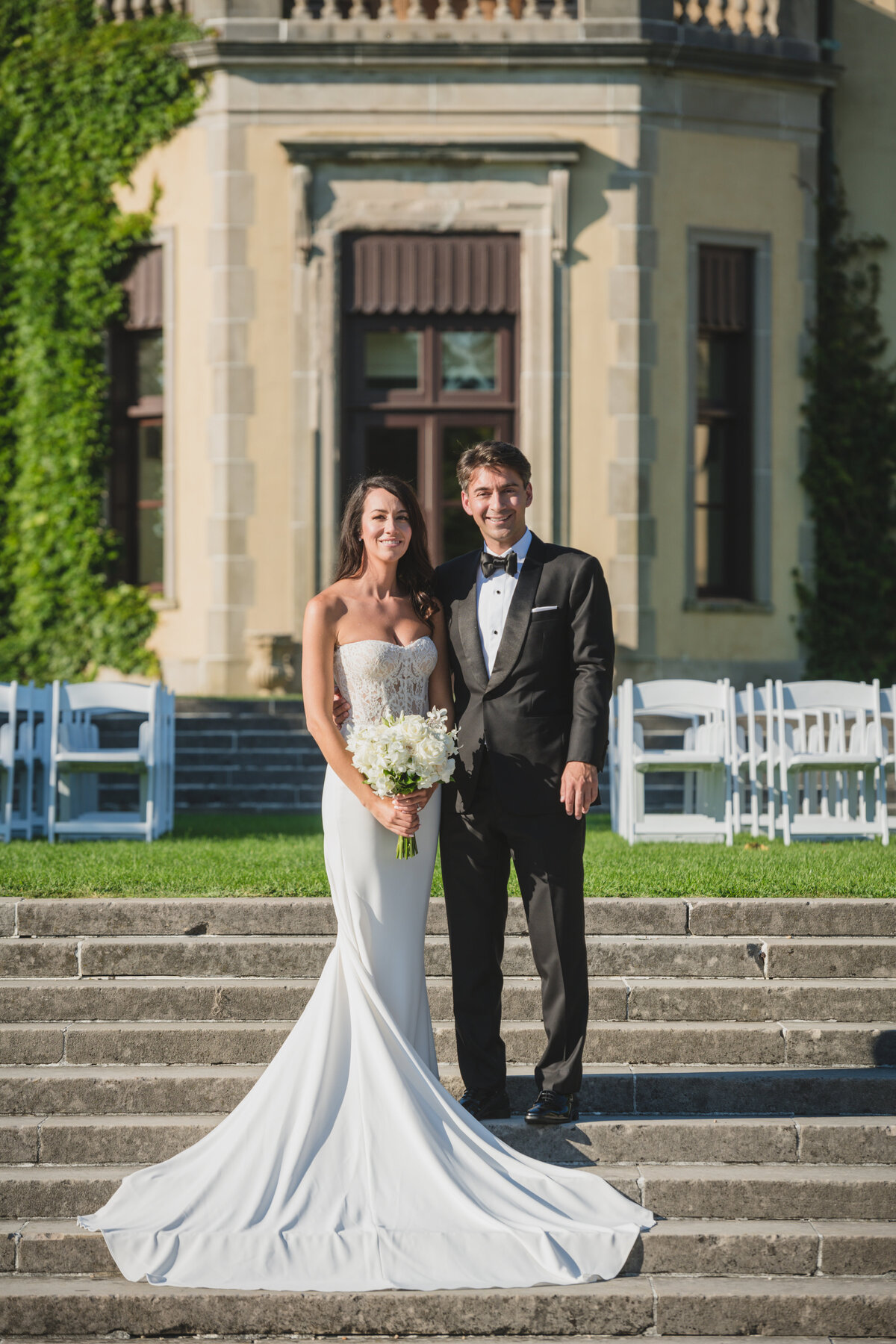 bride and groom standing outside Oheka Castle