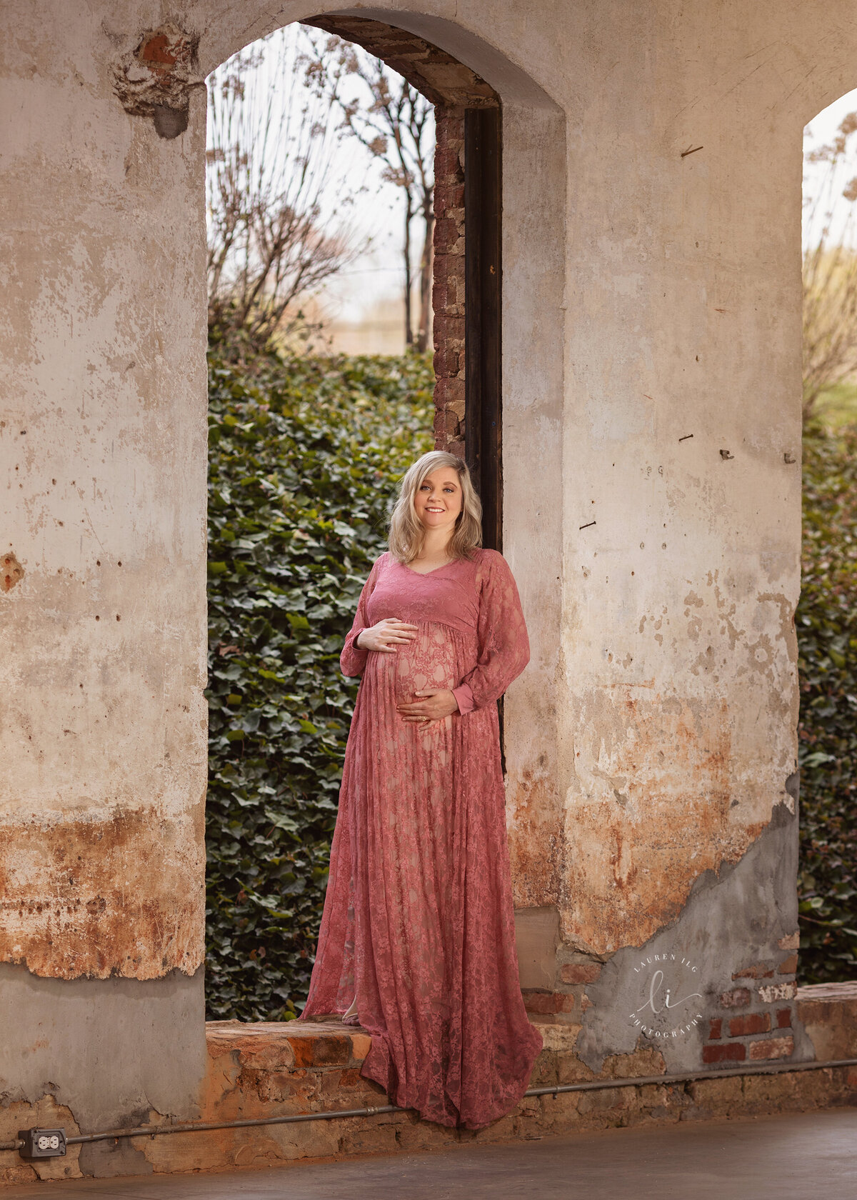 The Providence Cotton Mill Maiden, NC maternity session with mom standing in open window in pink gown