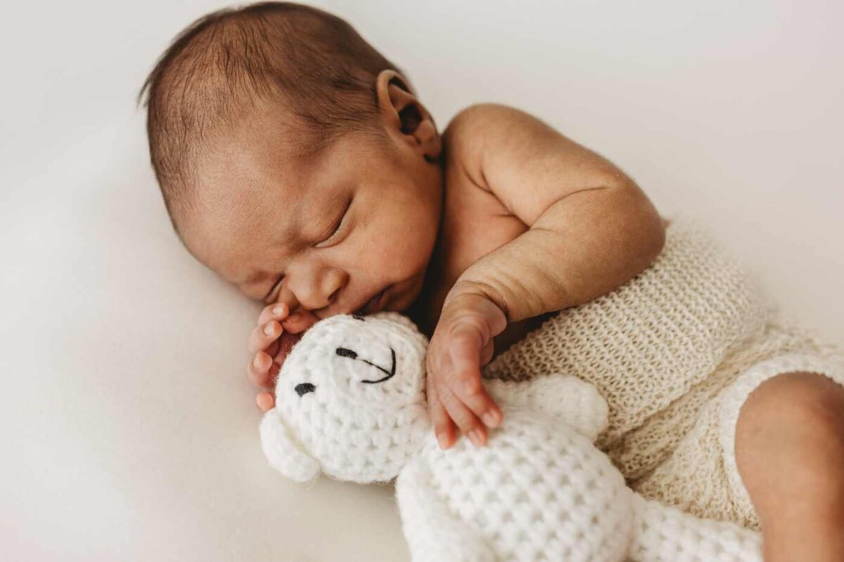 Ruua Hamdan Photography (UK): A sleeping baby rests with a white teddy bear.
