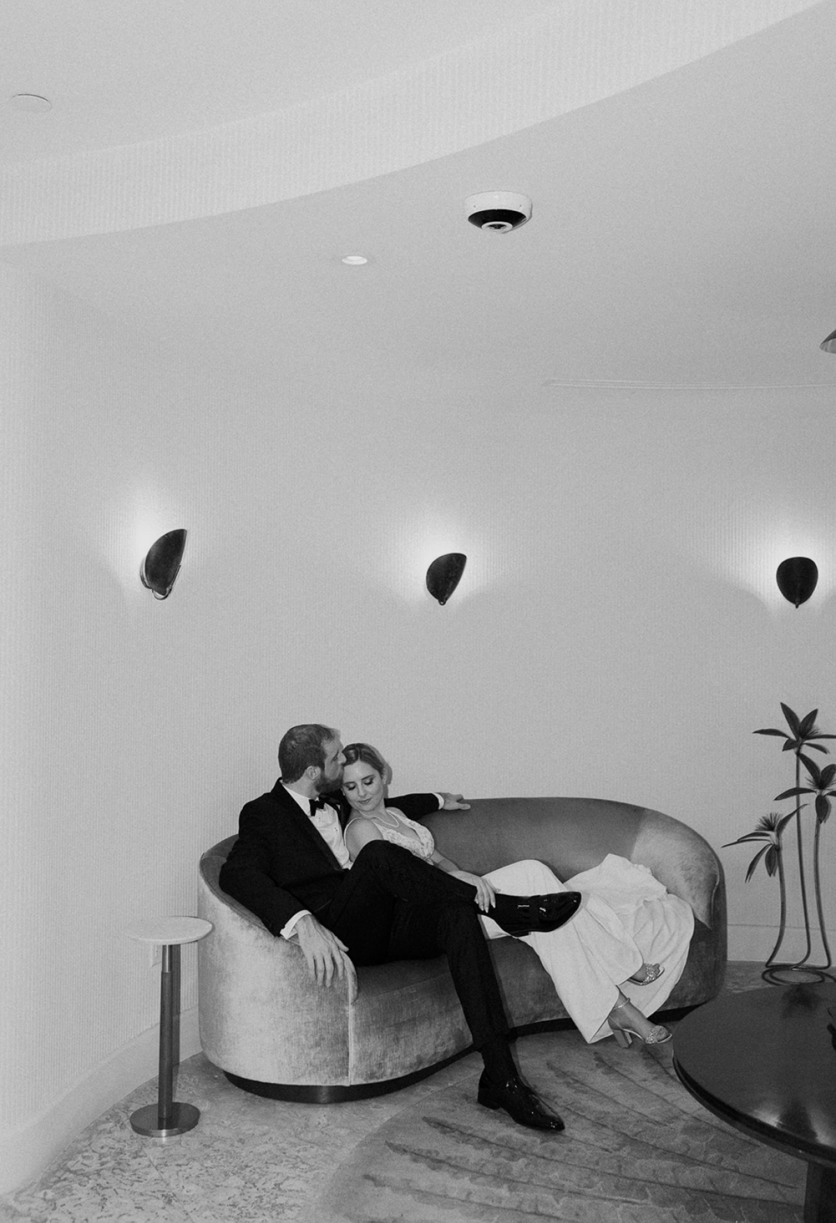 Bride and groom sitting on a couch in an elegant setting, captured by Claudia Amalia, a wedding and lifestyle photographer based in Miami and Florida Keys, South Florida. Destination weddings available. Portfolio highlight.