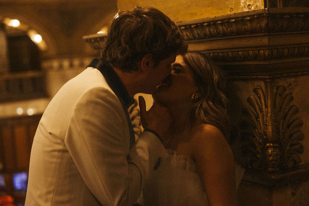 A couple kissing in a hotel hallway.