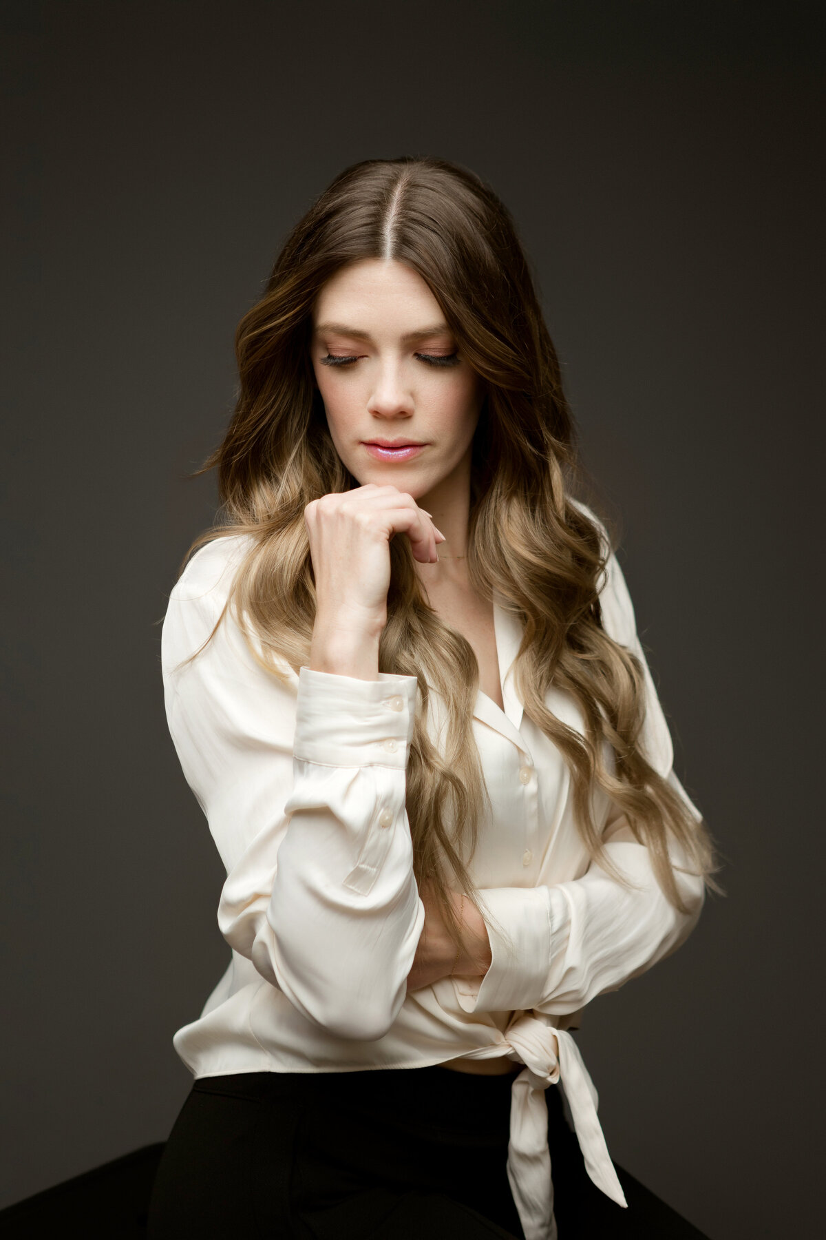 Headshot of a beautiful woman in a cream silk blouse