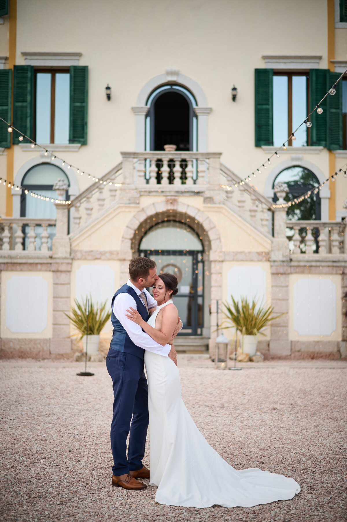 Hochzeitspaar in inniger Pose vor der Villa Cariola am Gardasee. 