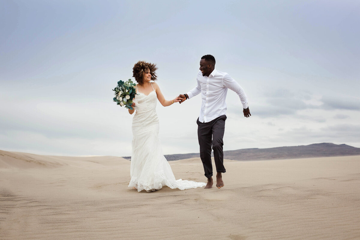 couple running off together after wedding at beach