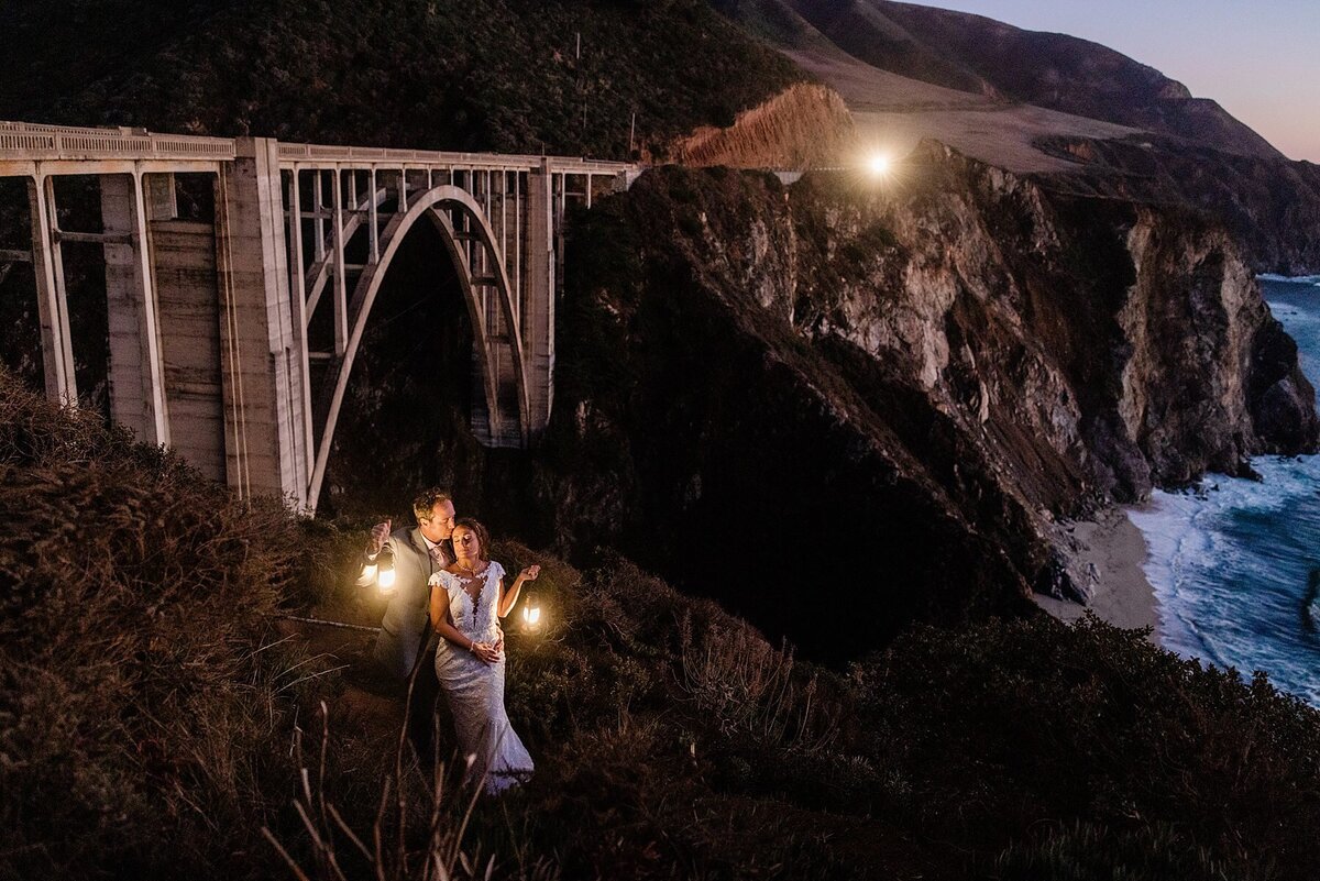 The bride and groom hold lanterns during their Big Sur elopement at Bixby Bridge.