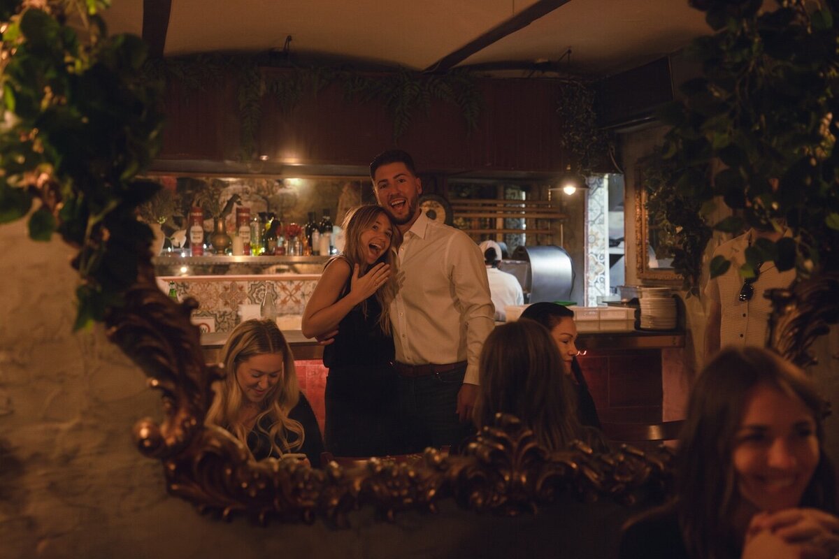 Dinner celebration after the proposal with wine and laughter.