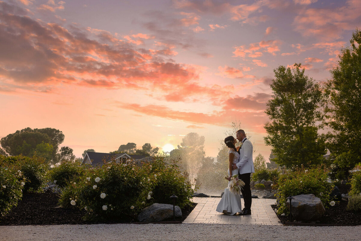 sunset-wedding-photo-garden-venue-bride-and-groom-romantic-kiss