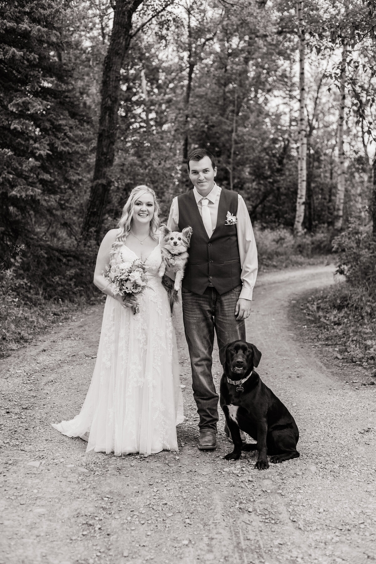 Bride and groom pose with theit two dogs