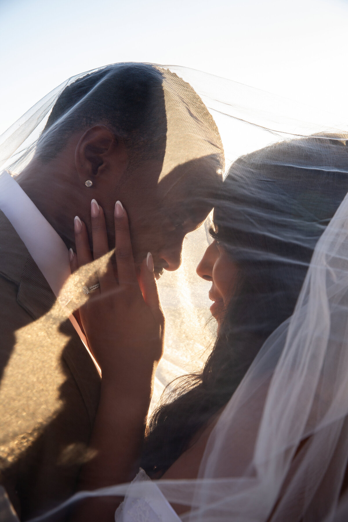 Couple post ceremony wedding photography during sunset with veil.