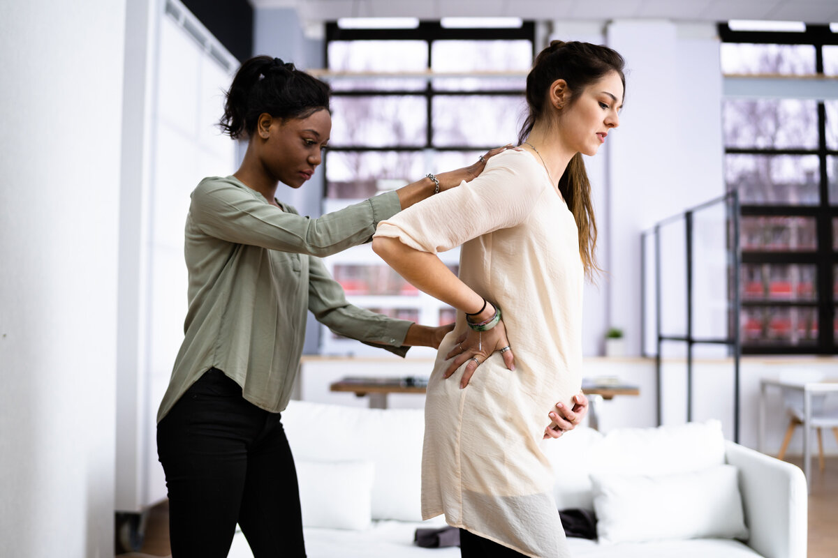 Pregnancy woman standing with hands on her belly.