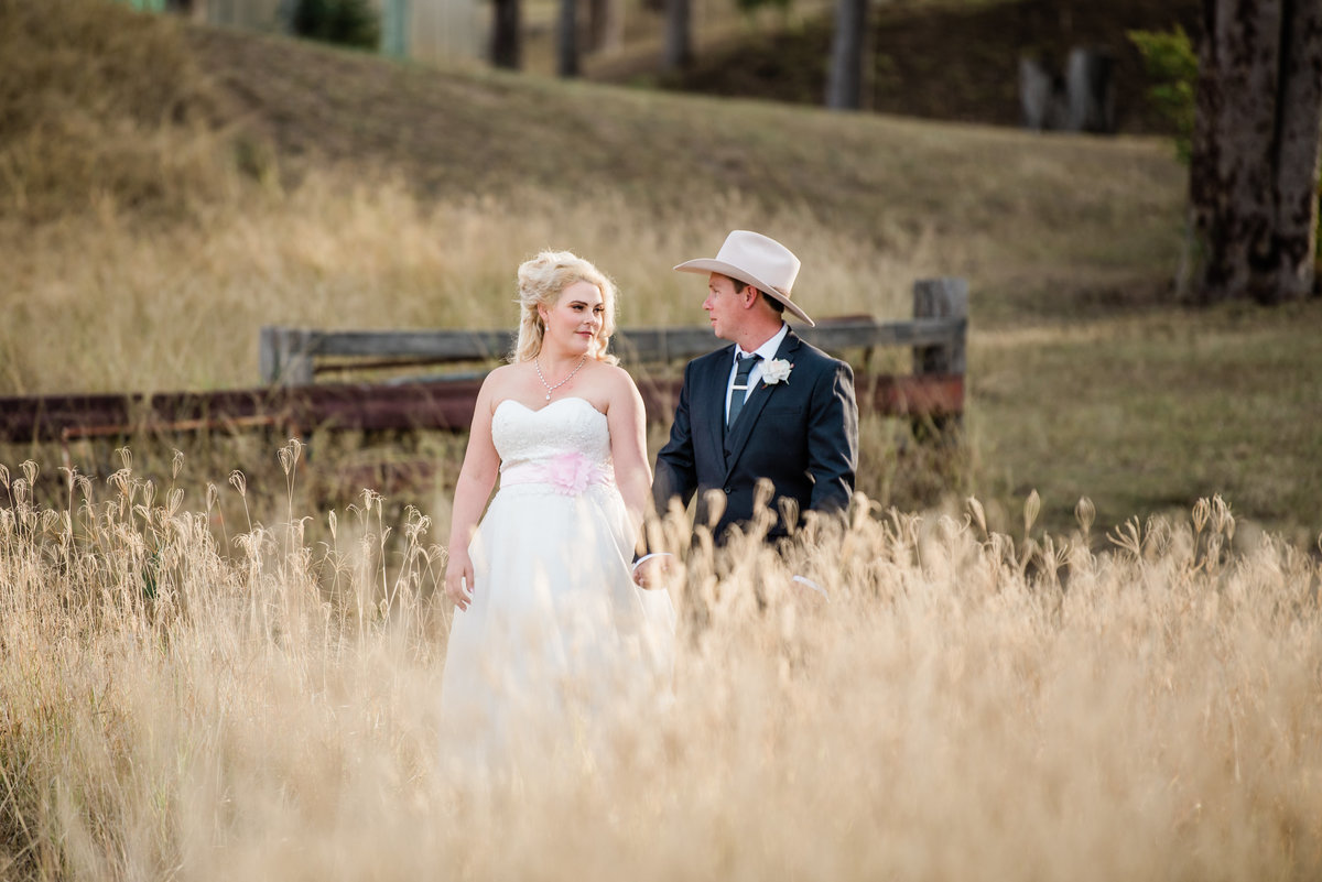 Minden-Retreat-Country-wedding-bride-and-groom-walk-in-grassy-field (1 of 1)