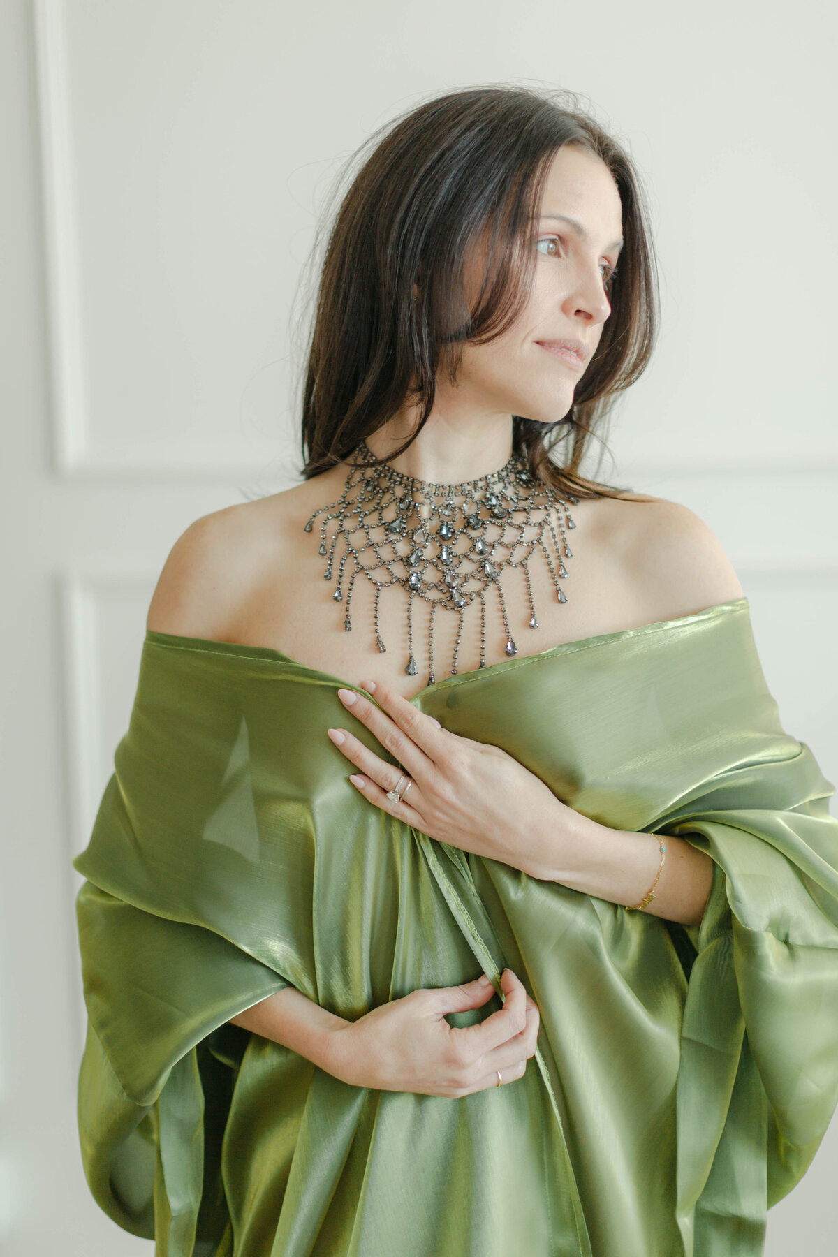 woman in green robe with statement necklace