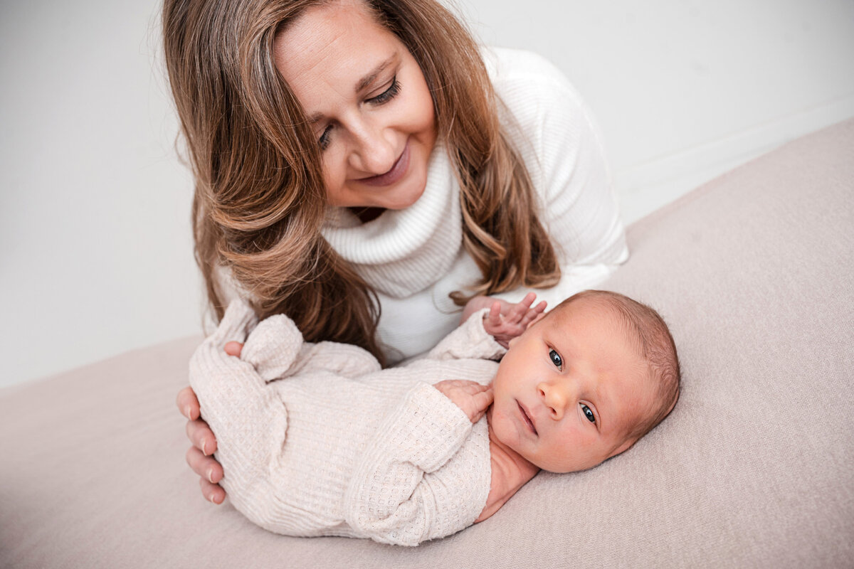 mom snuggling with newborn baby boy in studio photo session