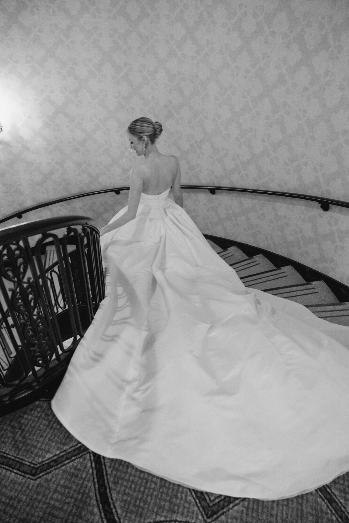 Black and white image of a bride going down the stairs at the Palmer House in Chicago.