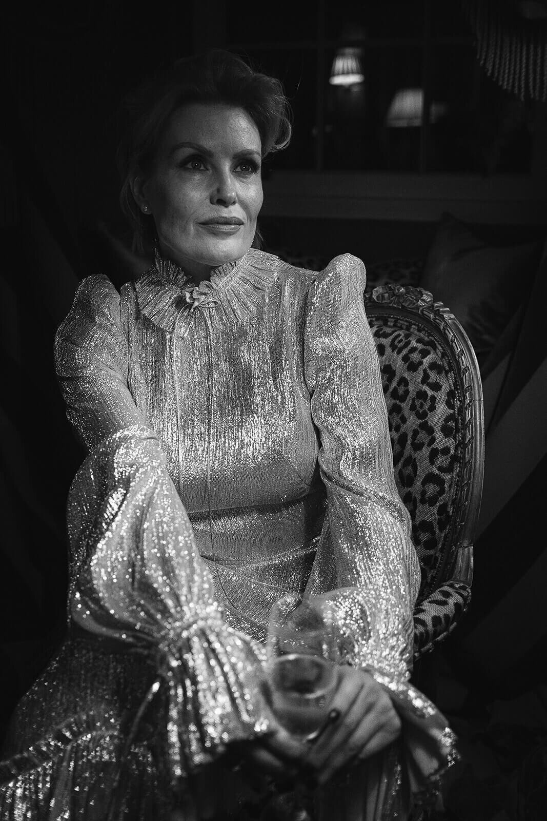 Bride is a classy silver dress with puff sleeves sat in a chair.