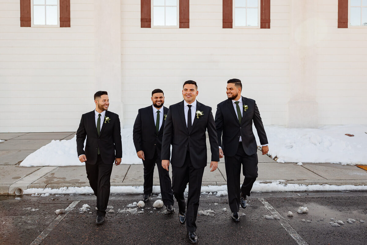 Groom and groomsman walking and laughing and celebrating on at creekside terrace in Colorado Springs, expertly shot by Michelle Betz Photography