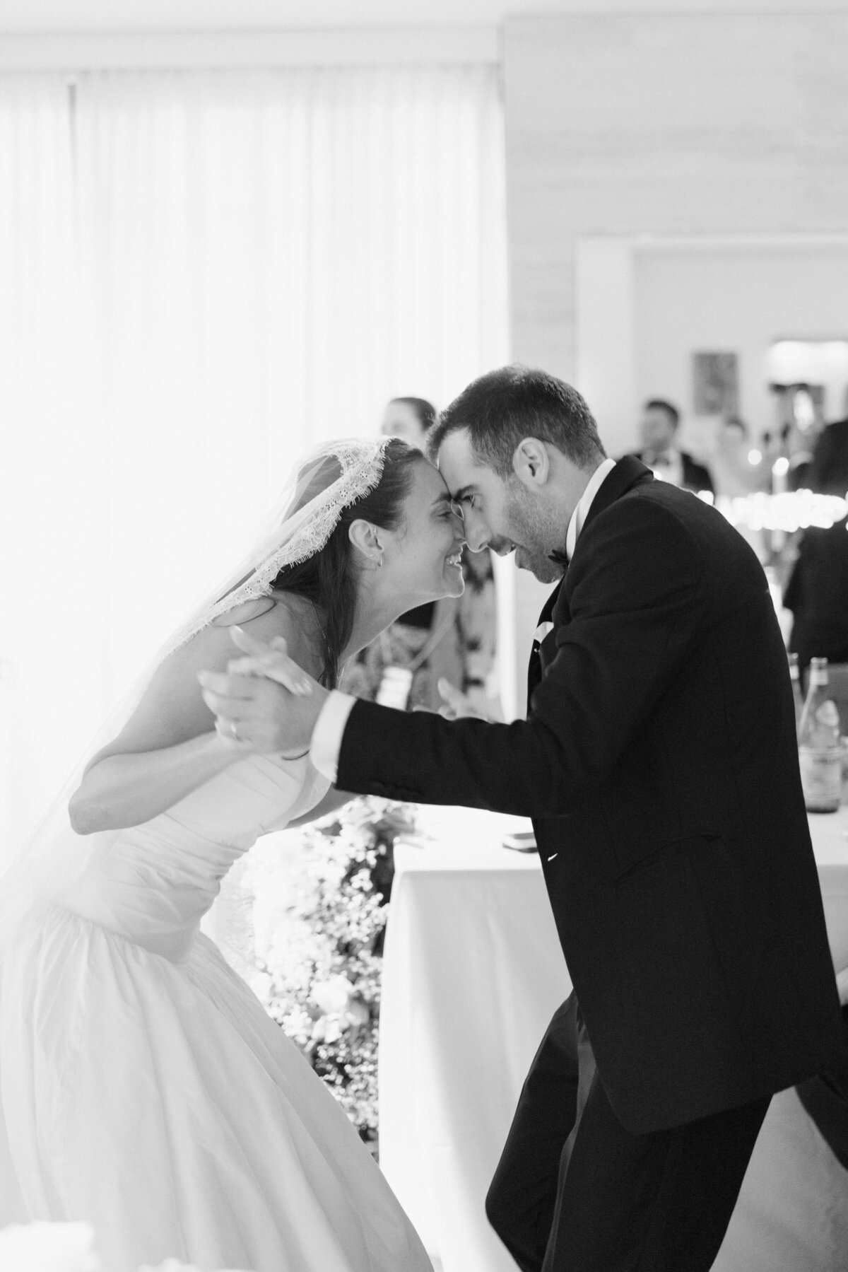Bride and groom sharing joyful first dance with live band in background

