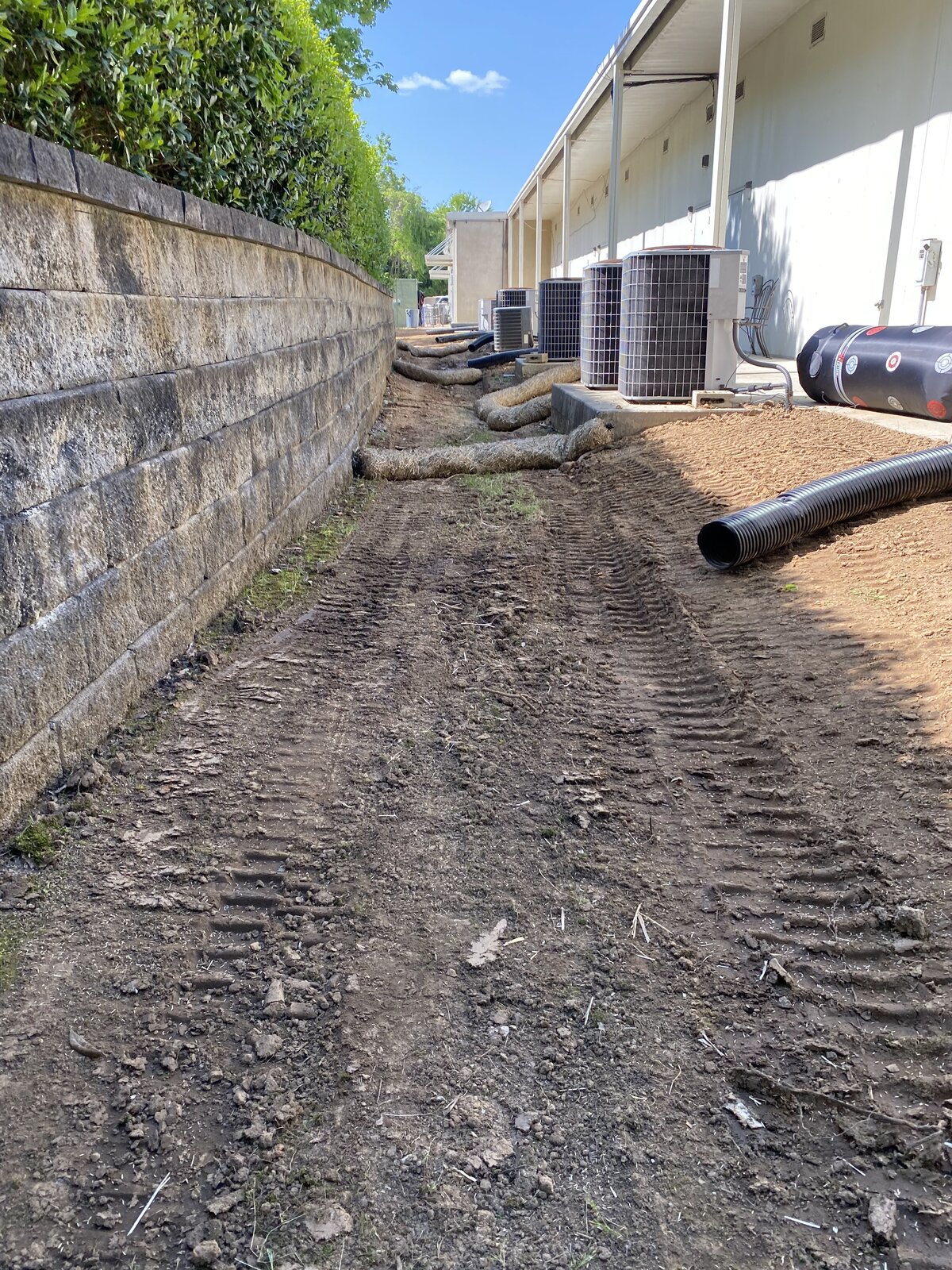 tire-tracks-in-dirt-next-to-stone-wall