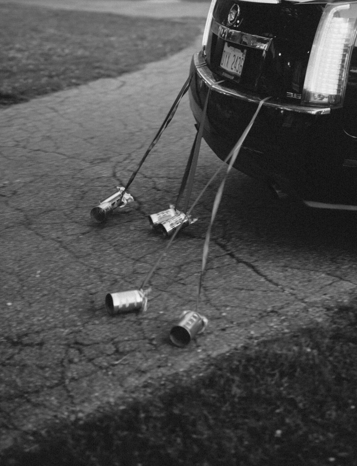 cans tied to wedding getaway car, documentary wedding photography in west Michigan
